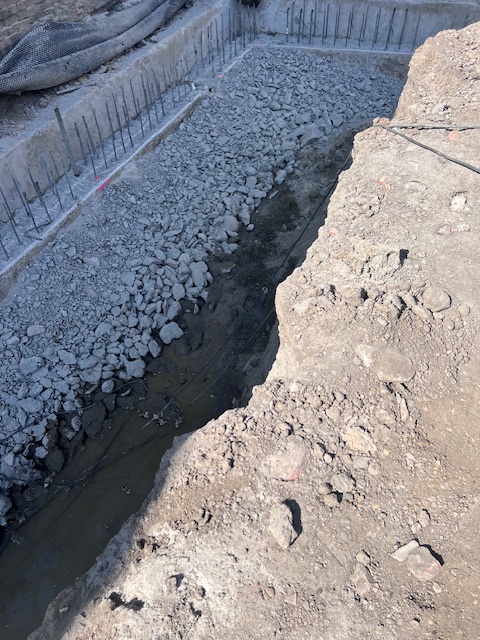 Wykop zabezpieczony betonowymi ścianami i zbrojeniem na placu budowy Ogrodowa 12 w Poznaniu, przygotowany do wykonania płyty fundamentowej.