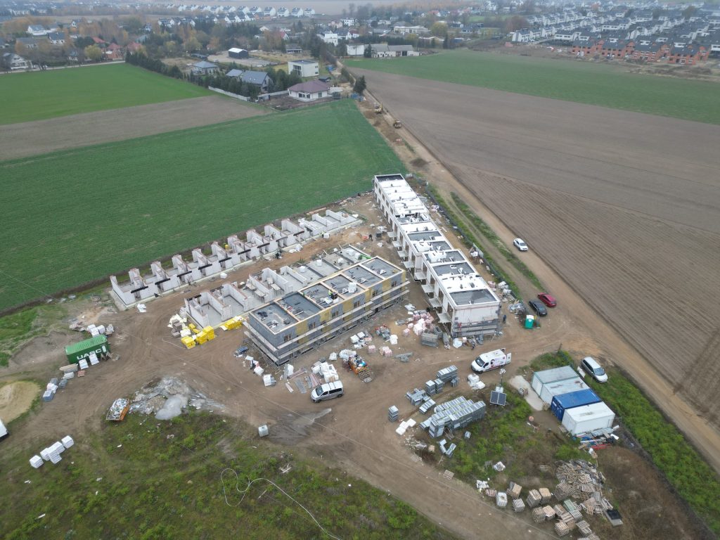 Widok na plac budowy inwestycji Rabowice Park Swarzędz z pracującymi ekipami budowlanymi.