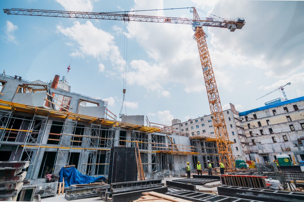 Budowa nowoczesnego budynku mieszkalnego z wykorzystaniem żurawia wieżowego i rusztowań

