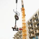 Zawieszenie tradycyjnej wiechy na budowie inwestycji Ogrodowa 12 w trakcie montażu konstrukcji przez dźwig, symboliczny etap zakończenia stanu surowego.