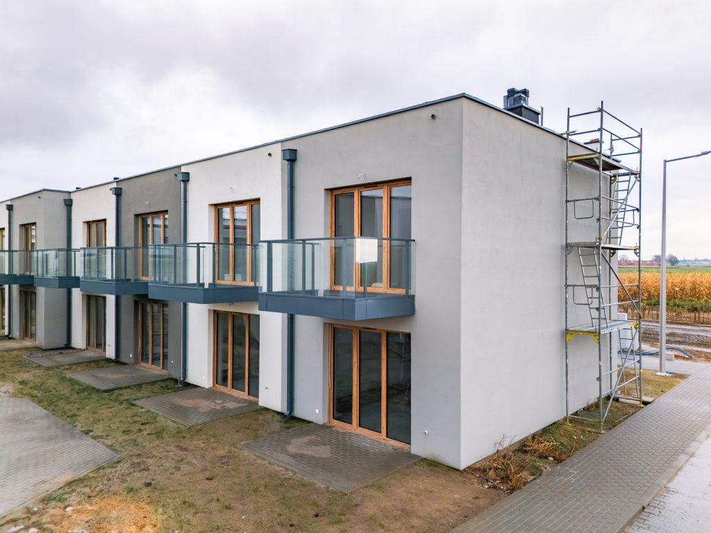 Rabowice Park Swarzędz budowa – elewacja budynku z balkonami i dużymi przeszkleniami, widok od strony ogródków